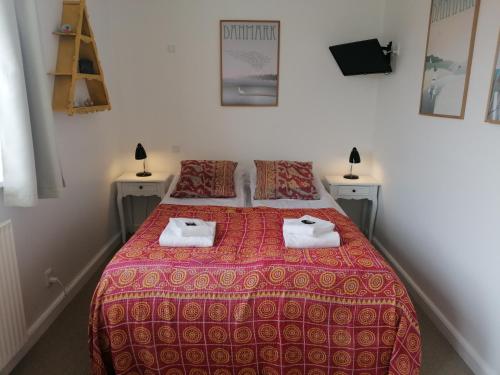 een slaapkamer met een bed met twee handdoeken erop bij Femmasteren Hotel & Hostel in Marstal