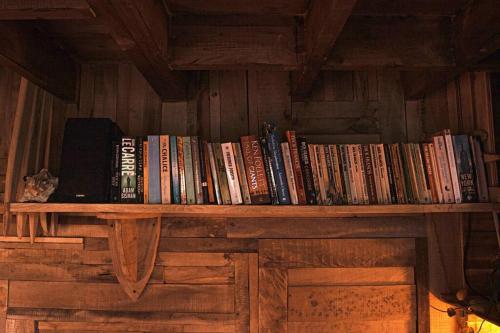 a shelf of books on a wooden wall at The Bristol Coach House in the heart of Bishopston in Bristol