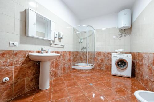 een badkamer met wastafel en wasmachine bij Tirana Center Apartment 12 in Tirana