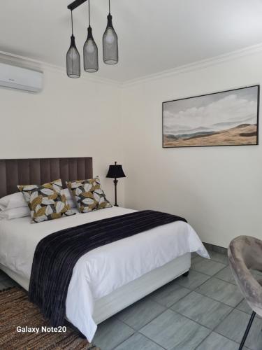 1 dormitorio con 1 cama grande y 1 silla en Egerton Overnight en Kimberley
