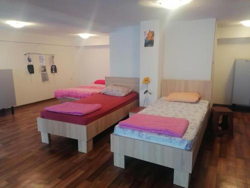 two beds in a room with wooden floors at Blue Lake hostel in Ohrid