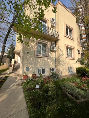 ein weißes Haus mit Fenstern und Pflanzen davor in der Unterkunft Cabbage Hostel in Belgrad