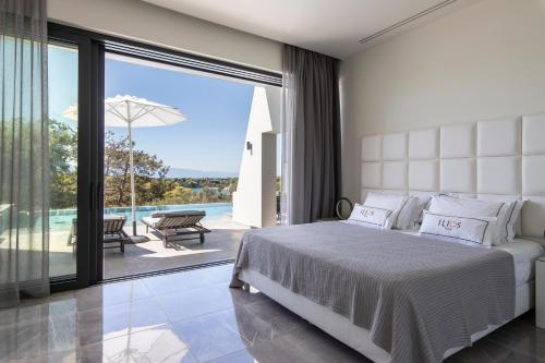 a bedroom with a bed and a view of a pool at Ilios Villa in Porto Heli