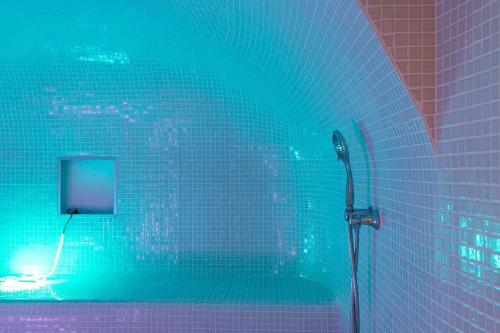 baño con ducha con luz verde en Seaview Villa en San Antonio