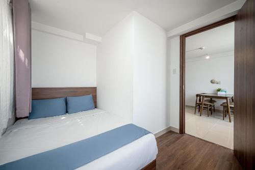 a bedroom with a large bed and a table at Cozrum Homes - Sonata Residence in Ho Chi Minh City