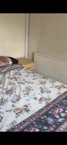 1 dormitorio con 1 cama con colcha de flores en 132 en Bushbury