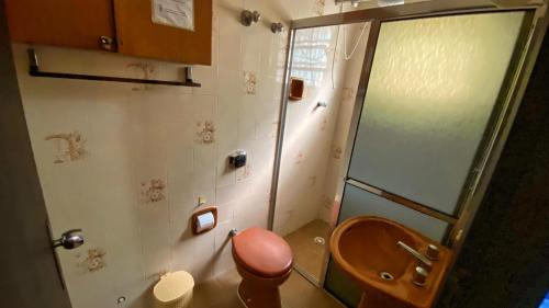 uma casa de banho com um chuveiro e um WC em madeira em Casa uma Quadra da Praia das Asturias com área gourmet no Guarujá