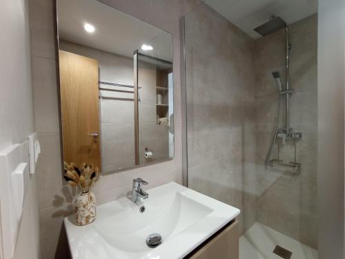 a white bathroom with a sink and a shower at Apartamento en El Prado in Cullera