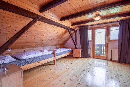 een slaapkamer met 2 bedden in een houten kamer bij River Valley View House in Bohinjska Bistrica