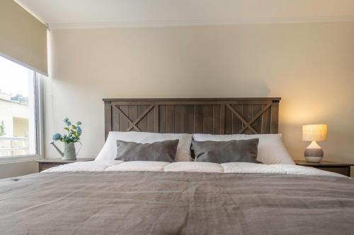 sypialnia z dużym łóżkiem z drewnianym zagłówkiem w obiekcie Praia 58 Reñaca w mieście Viña del Mar