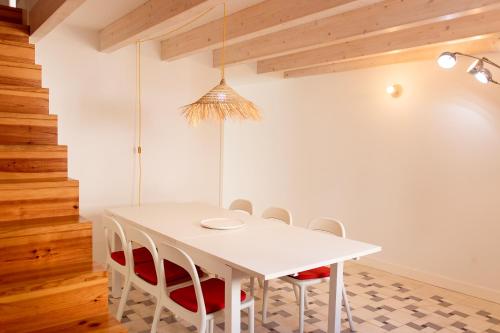 a dining room with a white table and chairs at Casa do Almirante in Tavira