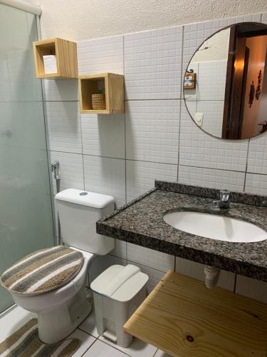 a bathroom with a toilet and a sink and a mirror at Lindo Flat Na Paradisíaca Praia da Taíba in Taíba