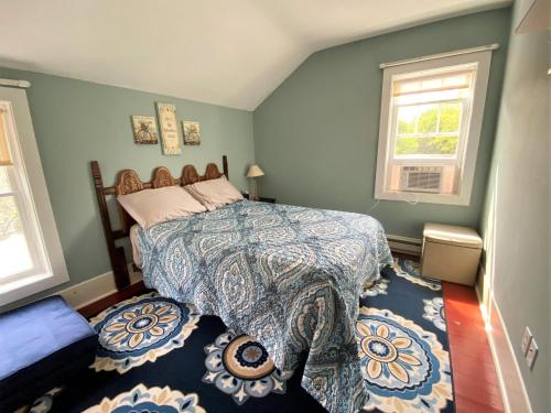 - une chambre avec un lit et un mur bleu dans l'établissement UP Cottage, à Saint-Ignace