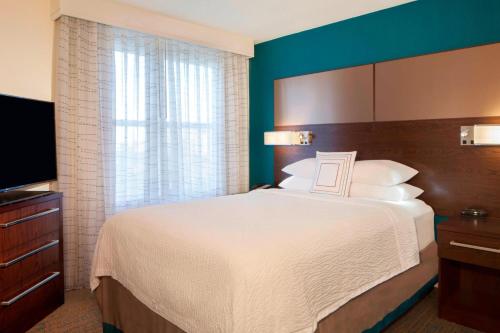 a hotel room with a bed and a television at Residence Inn Tampa Downtown in Tampa