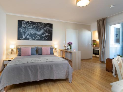 1 dormitorio con 1 cama grande con almohadas rosas y azules en Ferienwohnung im Herzen vom Sylt, en Westerland