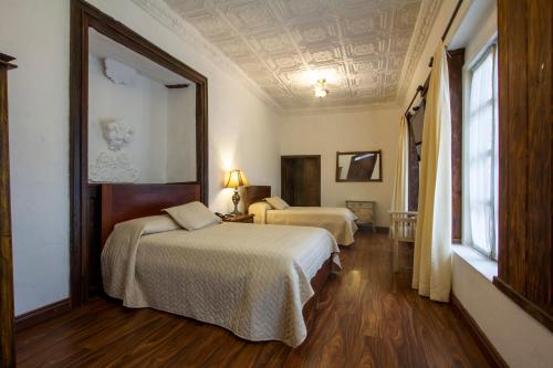 a hotel room with two beds and a ceiling at Hotel Inca Real in Cuenca