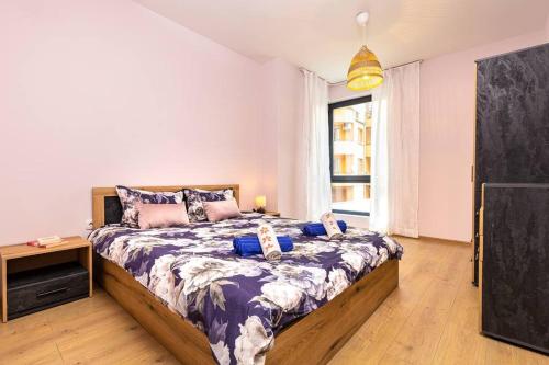 a bedroom with a large bed and a large window at Brand New Modern 1BR Apartment with Private Parking included in Plovdiv