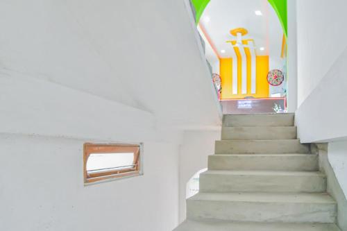 a staircase in a building with a sign on the wall at SPOT ON Nirvaan Guest House in Kāhārpāra