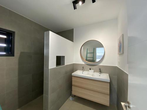 een badkamer met een wastafel en een spiegel bij Casa Monte y Mar in Morro del Jable