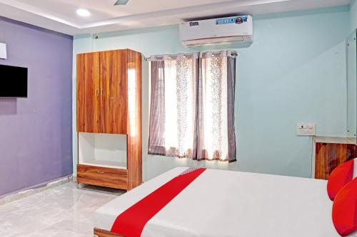 ein Schlafzimmer mit einem großen Bett und einem Fenster in der Unterkunft Sai Leela Residency in Karīmnagar