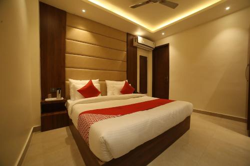 - une chambre avec un grand lit et des oreillers rouges dans l'établissement Super OYO Status Inn, à Dehradun