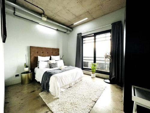 a bedroom with a bed and a large window at Hallmark Apartment in Johannesburg