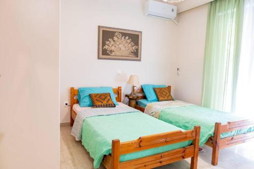 1 dormitorio con 2 camas individuales y sofá en My Aegean Sea Apartment en Cos