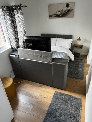 1 dormitorio con cama y sofá en Tranquil Gardens, en Loughborough