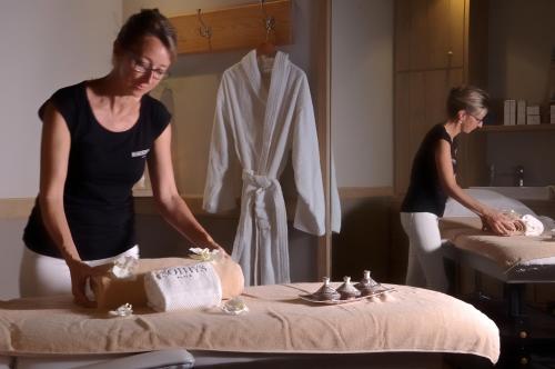 two women standing in a room with a table at Les Glycines - Hôtel & Spa - Teritoria in Les Eyzies-de-Tayac