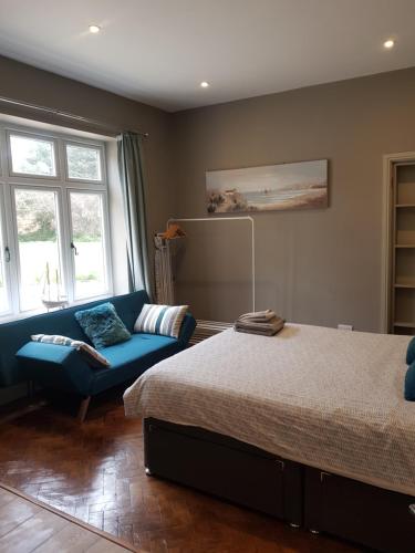 sypialnia z łóżkiem, kanapą i oknem w obiekcie The New Forest Manor Apartment w mieście Lymington