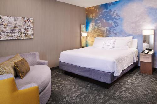 a hotel room with a bed and a chair at Courtyard Toledo Rossford/Perrysburg in Rossford