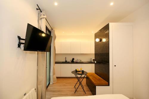 Il comprend un salon avec une télévision et une cuisine. dans l'établissement Studio fonctionnel tout équipé proche métro - 2P - FLAT-GUEST, à Paris