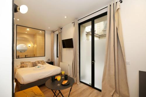 a bedroom with a bed and a table and a window at Studio fonctionnel tout équipé proche métro - 2P in Paris