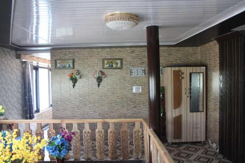 un pasillo con una escalera con flores en la pared en OYO Home Nafeel Homestay, en Pahalgām