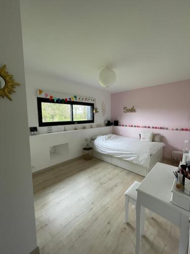 1 dormitorio con cama, ventana y mesa en Chambres privées dans fermette rénovée proche du Mans au calme, en Changé