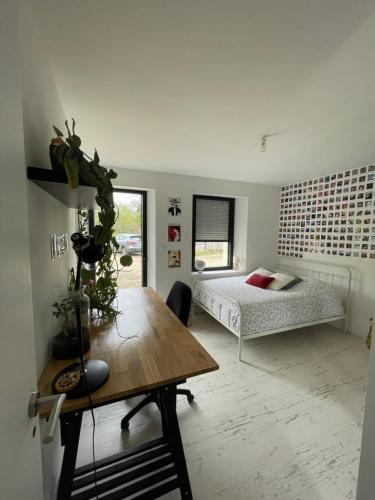 1 dormitorio con cama, mesa y escritorio en Chambres privées dans fermette rénovée proche du Mans au calme, en Changé