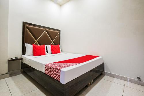 a large bed with red pillows in a room at Hotel Sunrise in Ludhiana