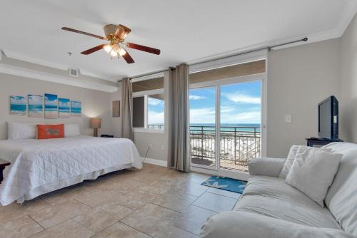 een slaapkamer met een bed, een bank en een balkon bij Seahorse unit I in Pensacola Beach