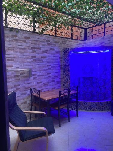 a patio with a table and chairs and a blue screen at Mohamed V Airport Home in Deroua
