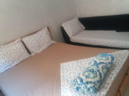 a room with two beds and a table with a couch at Mohamed V Airport Home in Deroua