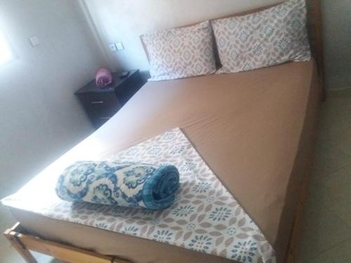 a bed with a pillow on top of it at Mohamed V Airport Home in Deroua