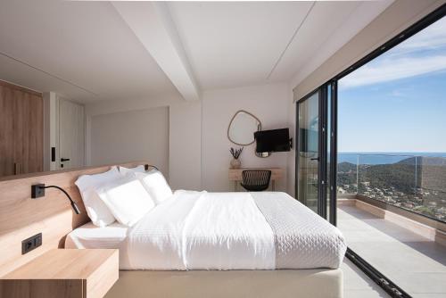 a bedroom with a white bed and a large window at Saronida Hills in Saronida