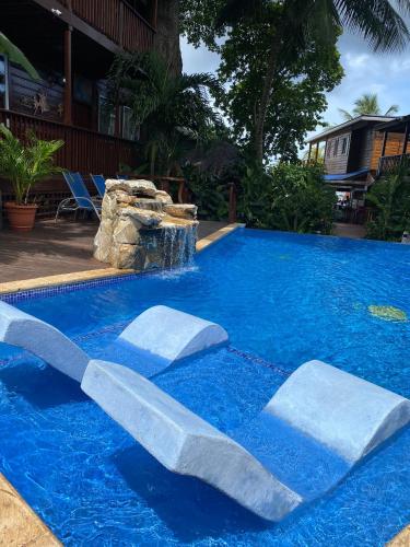 a swimming pool with a waterfall in the middle at Blue Bahia Resort in Sandy Bay