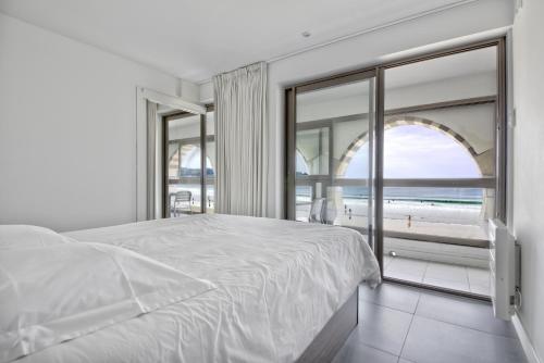 a bedroom with a bed and a view of the ocean at Pavillon Itsasoan in Hendaye