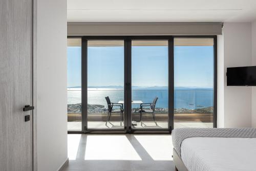 una camera da letto con tavolo e sedie su un balcone di Saronida Hills a Saronida