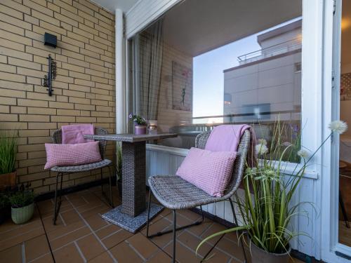 eine Terrasse mit 2 Stühlen und einem Tisch auf dem Balkon in der Unterkunft Ferienwohnung im Herzen vom Sylt in Westerland