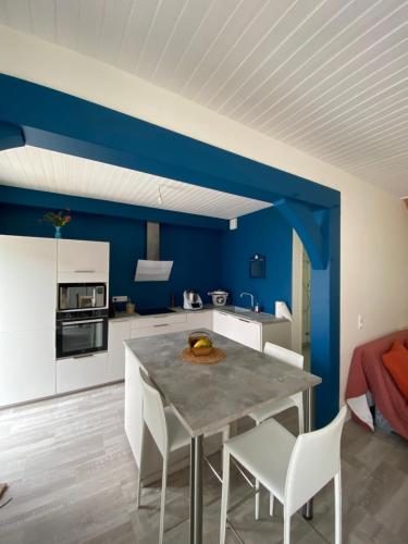 une cuisine bleue avec une table et des chaises blanches dans l'établissement Saint Georges de didonne, à Saint-Georges-de-Didonne