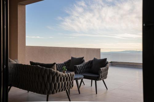 a balcony with chairs and a table and a view at Saronida Hills in Saronida