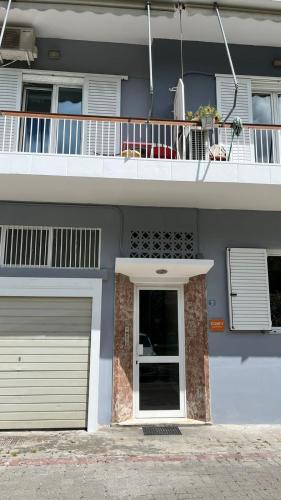 a blue house with a garage and a balcony at Comfy Apartment in Nafplio
