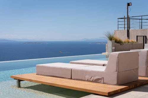 a pool with two lounge chairs on a table next to the water at Saronida Hills in Saronida